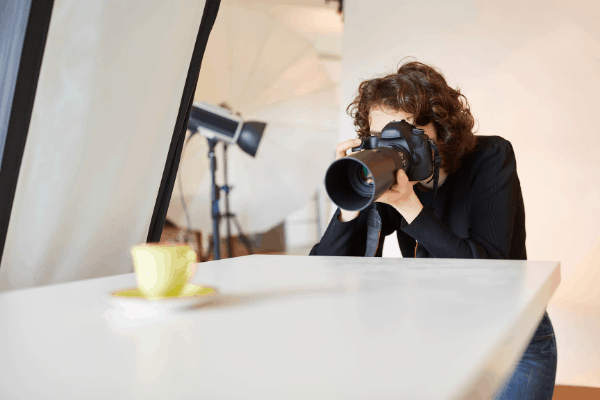 google friendly product reviews - woman taking a picture of tea cup with studio background